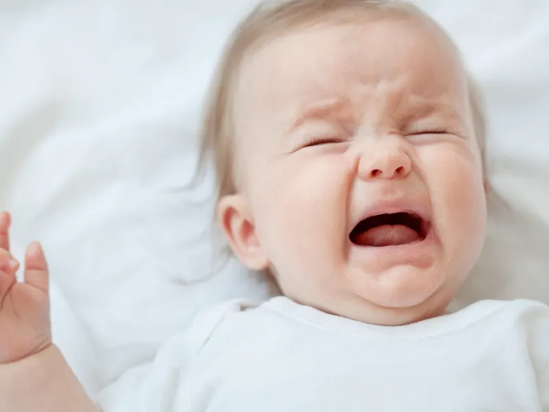 Bé khóc khi thay bỉm do đói bé đang buồn ngủ